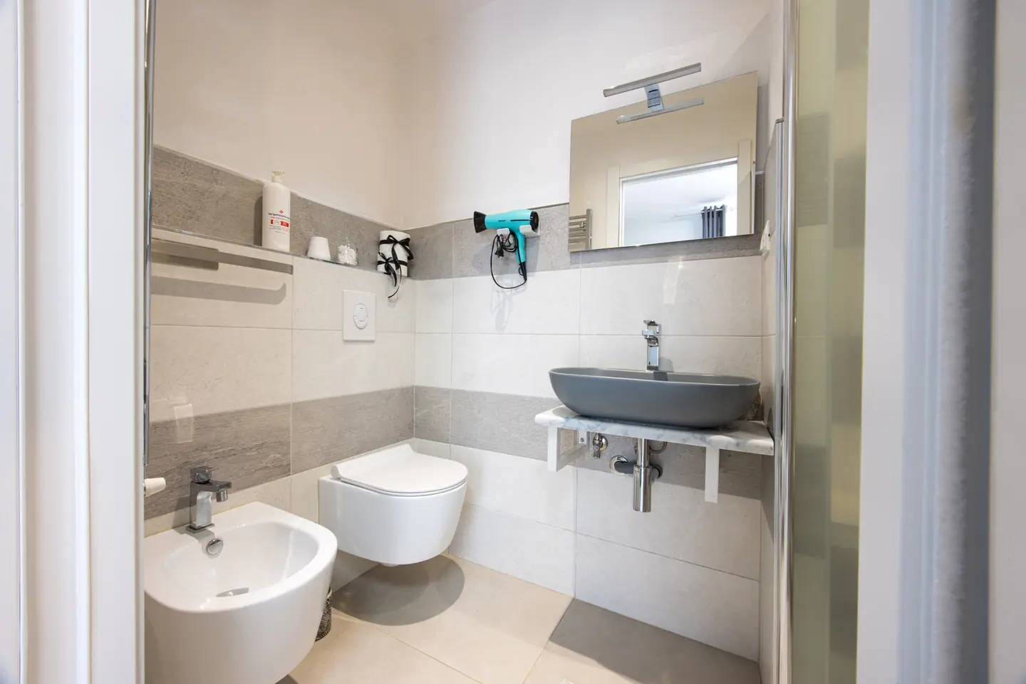 Il bagno privato con lavabo ovale grigio opaco su mensola in marmo