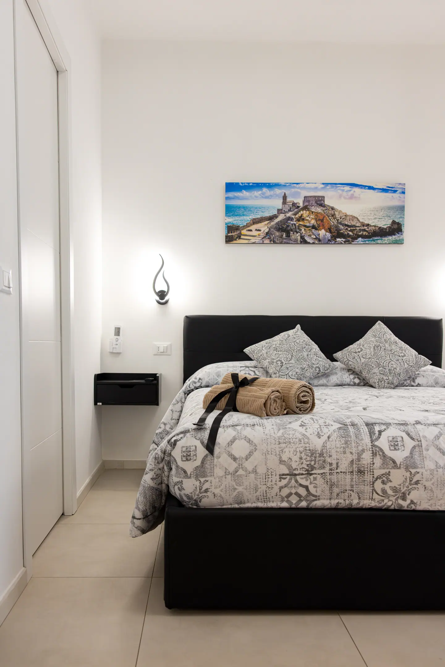 La camera vista dalla porta, con il letto in similpelle nera
